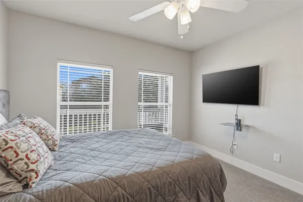 a bedroom with a bed tv and a window