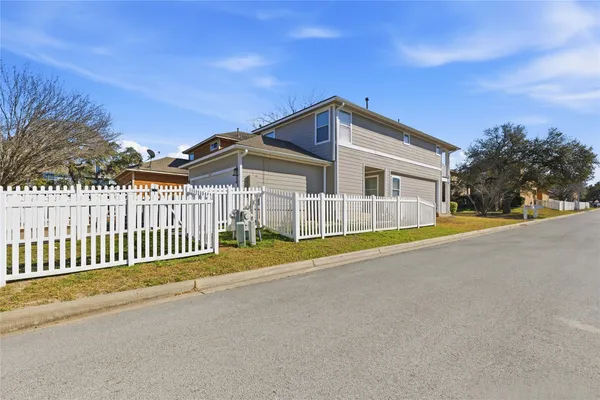 a view of a house with a swimming pool and wooden fence