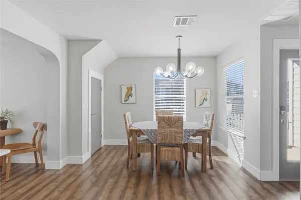 a view of a dining room with furniture a chandelier and wooden floor