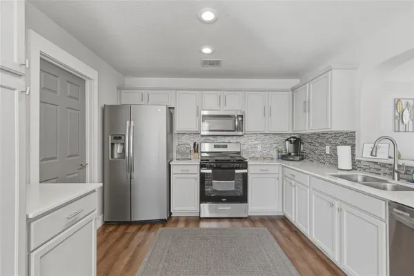 a kitchen with stainless steel appliances granite countertop a refrigerator sink and stove