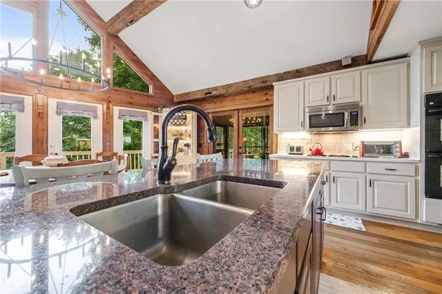 a kitchen with stainless steel appliances granite countertop a sink and a refrigerator