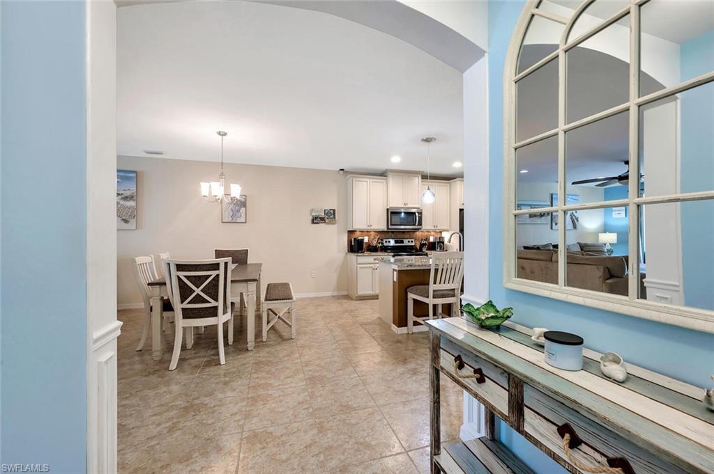 14940 Edgewater Circle Naples, FL 34114 - Photo 12 of 39 a kitchen with stainless steel appliances kitchen island granite countertop a stove and a refrigerator