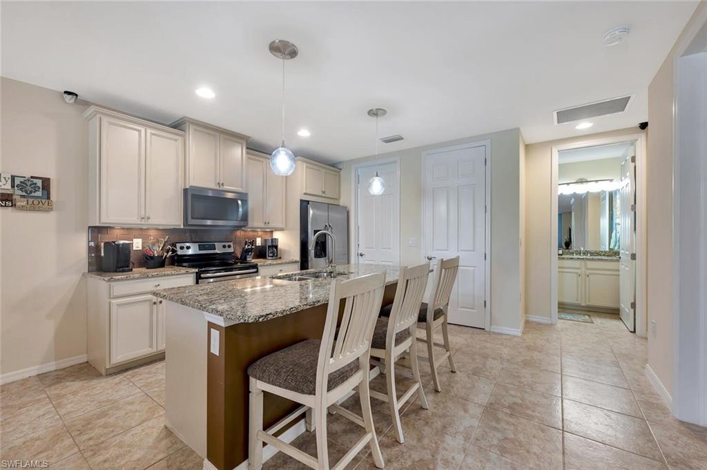 14940 Edgewater Circle Naples, FL 34114 - Photo 16 of 39 a kitchen with kitchen island granite countertop stainless steel appliances cabinets a sink and a island
