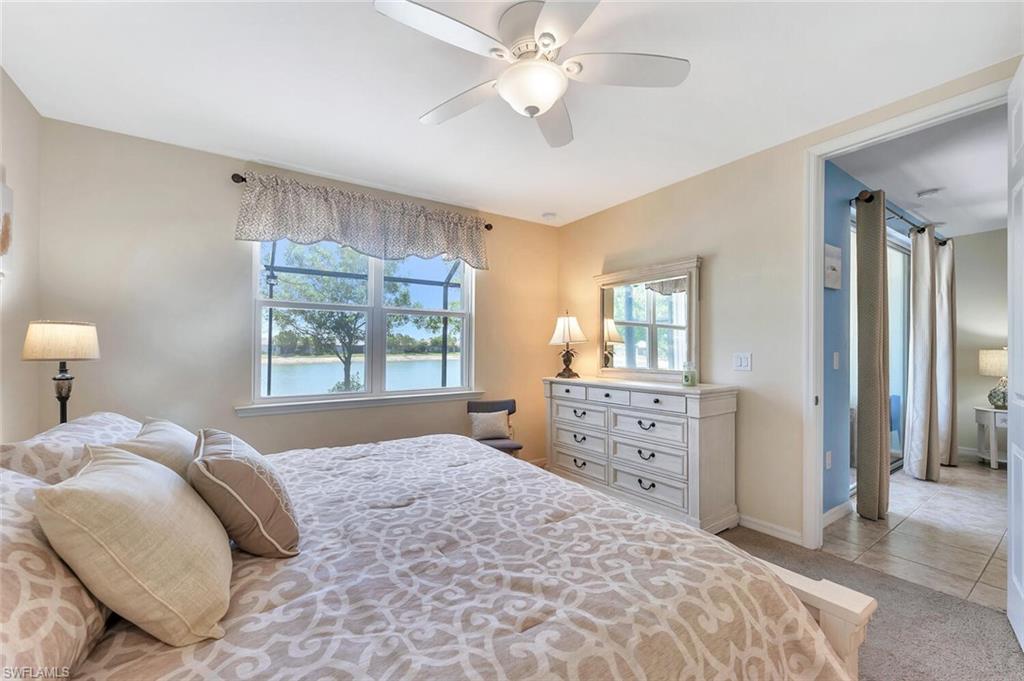 14940 Edgewater Circle Naples, FL 34114 - Photo 17 of 39 a bedroom with a large bed and a chandelier