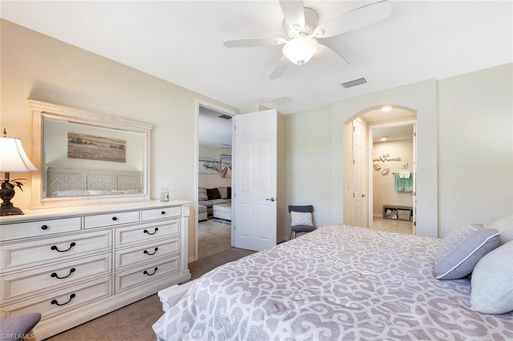 14940 Edgewater Circle Naples, FL 34114 - Photo 18 of 39 a bedroom with a bed and a dresser
