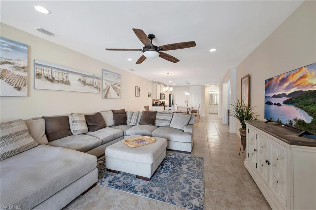 14940 Edgewater Circle Naples, FL 34114 - Photo 8 of 39 a living room with furniture and a flat screen tv