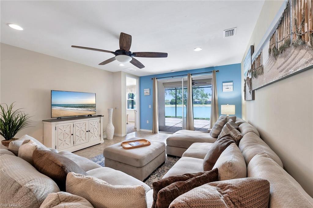 14940 Edgewater Circle Naples, FL 34114 - Photo 9 of 39 a living room with furniture and a flat screen tv