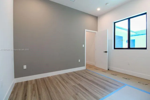 wooden floor in an empty room with a window