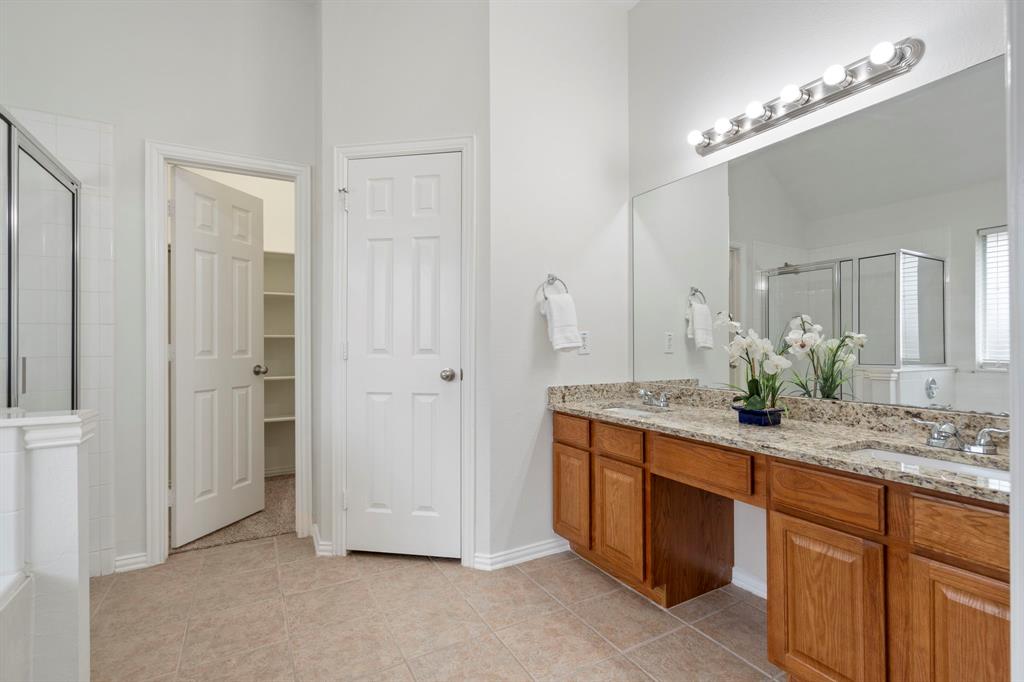 613 Hummingbird Trail Crowley, TX 76036 - Photo 20 of 37 a spacious bathroom with a granite countertop sink and a mirror
