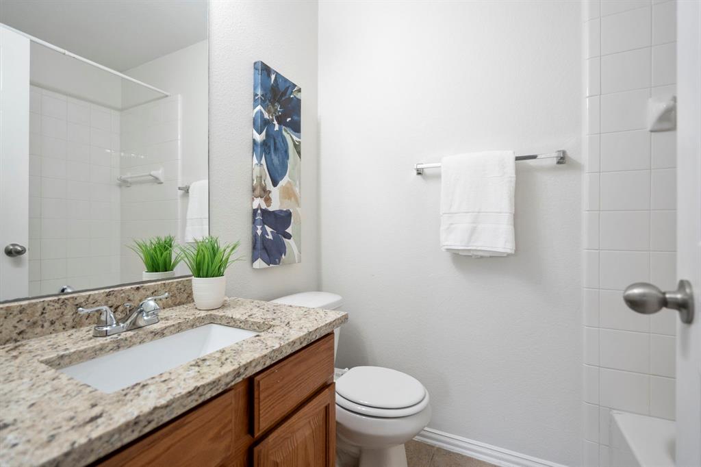613 Hummingbird Trail Crowley, TX 76036 - Photo 25 of 37 a bathroom with a granite countertop sink a toilet and a mirror