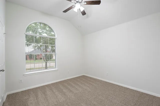 an empty room with chandelier fan