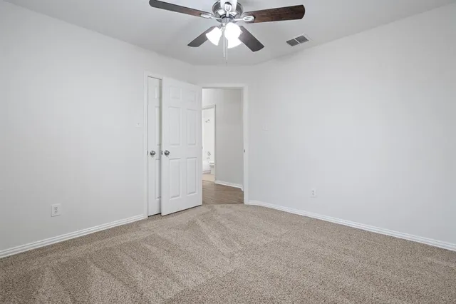 an empty room with windows and fan