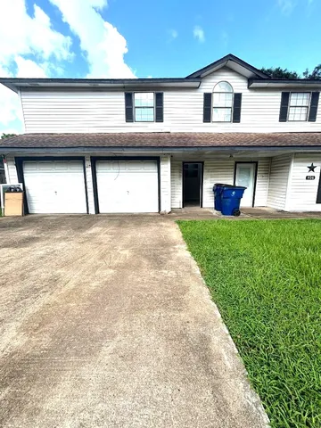 a front view of a house with a garden and garage