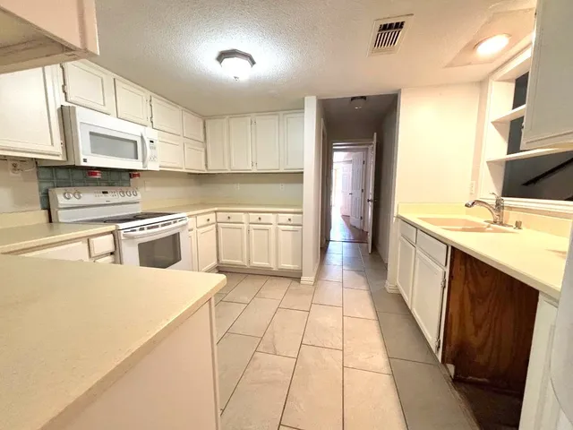 a kitchen with stainless steel appliances granite countertop a sink counter space cabinets and a large window