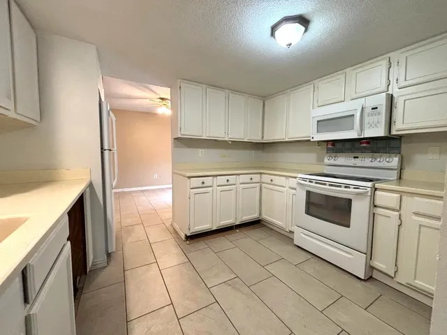 a kitchen with a stove sink and cabinets