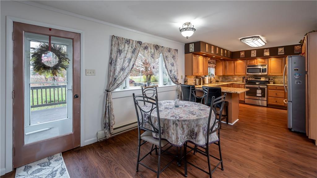 Eat-in kitchen with beautiful hardwood floors throughout the space.