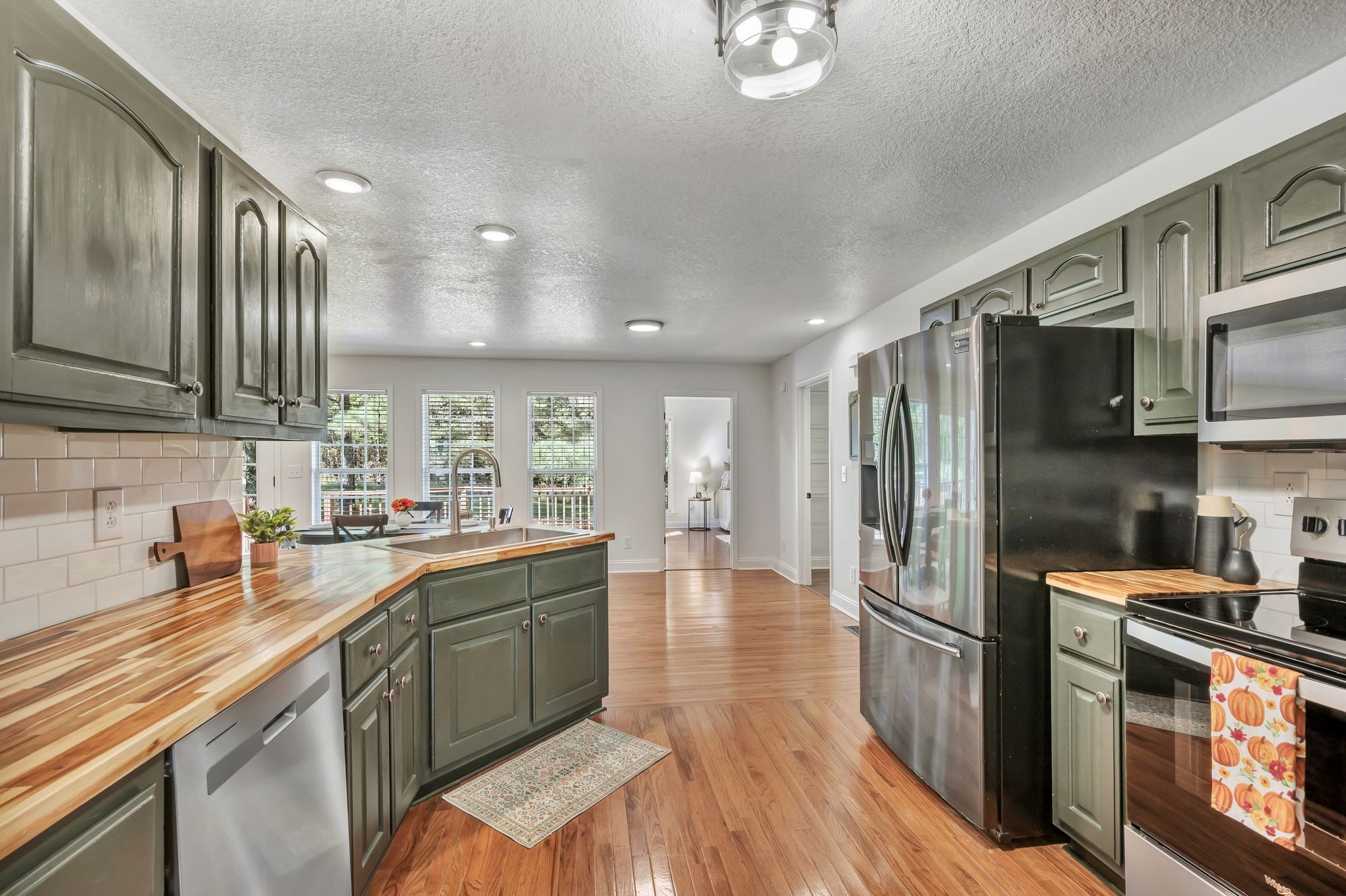 2044 Old Blacktop Road McEwen, TN 37101 - Photo 28 of 45 a kitchen with stainless steel appliances granite countertop a refrigerator a sink dishwasher a stove and white countertops with wooden floor