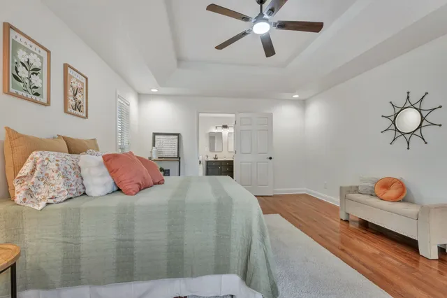 a bedroom with a large bed chandelier and a window