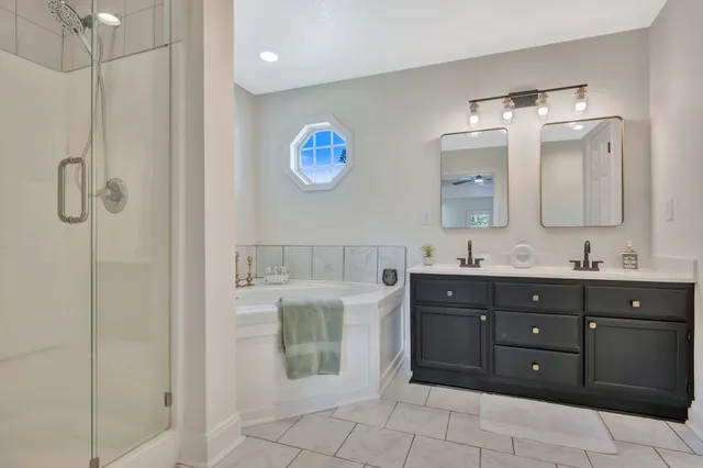 a bathroom with a granite countertop sink a mirror and a shower