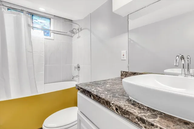 a bathroom with a granite countertop sink mirror toilet and bathtub