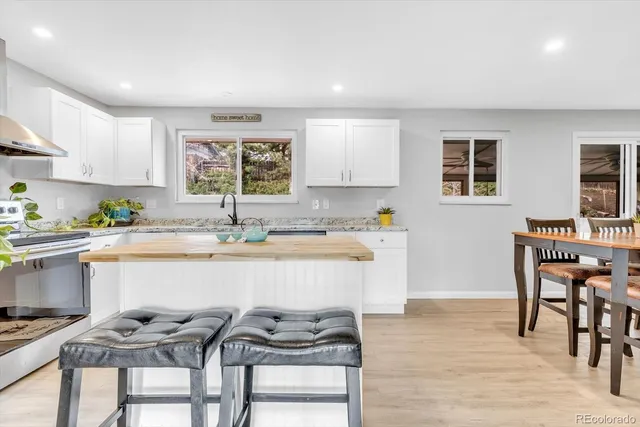 a kitchen with a table chairs sink and cabinets
