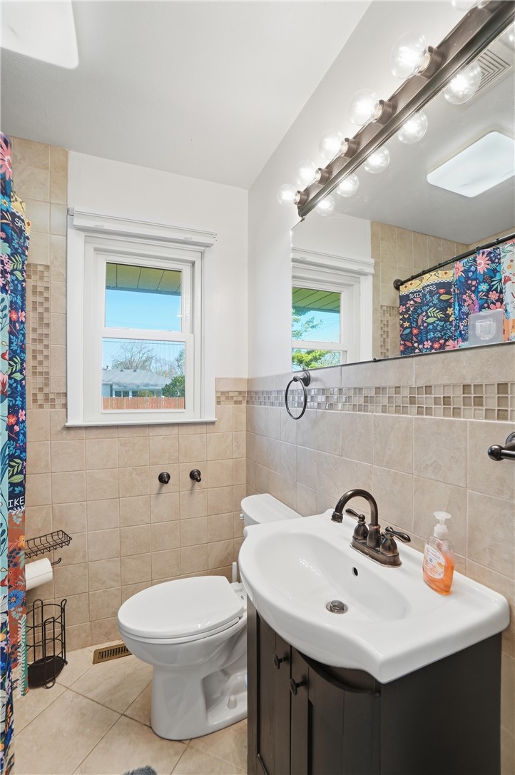 1325 Chelsea Road Troy, OH 45373 - Photo 23 of 42 This bathroom features a contemporary vanity and tiled walls, creating a clean and refreshing atmosphere.