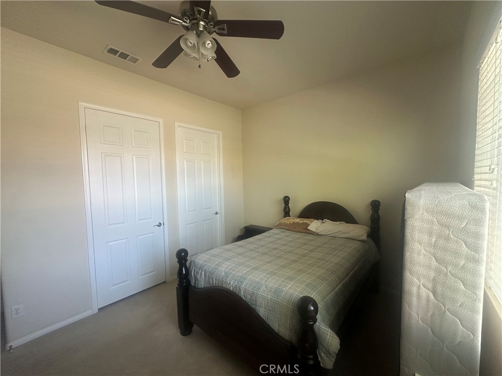 1185 Lantana Road Beaumont, CA 92223 - Photo 16 of 36 a bedroom with a bed and a chandelier