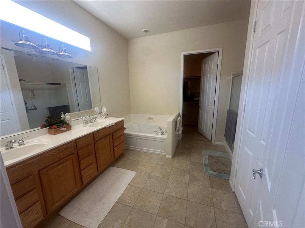 1185 Lantana Road Beaumont, CA 92223 - Photo 31 of 36 a bathroom with a double vanity sink a toilet and mirror