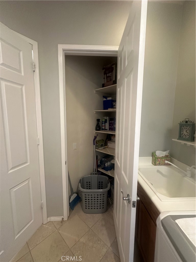 1185 Lantana Road Beaumont, CA 92223 - Photo 34 of 36 a kitchen with a refrigerator and white cabinets