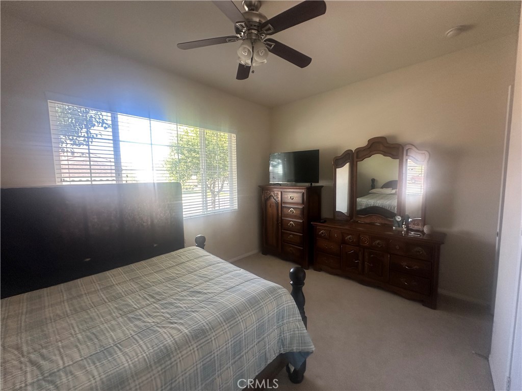 1185 Lantana Road Beaumont, CA 92223 - Photo 4 of 36 a bedroom with a bed and a chandelier