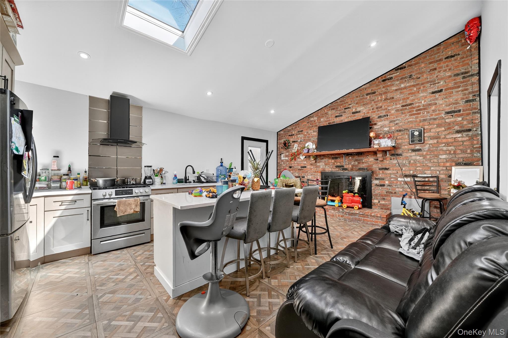 306 South Pascack Road Nanuet, NY 10954 - Photo 47 of 48 Kitchen featuring a skylight, appliances with stainless steel finishes, wall chimney range hood, a kitchen breakfast bar, and open floor plan