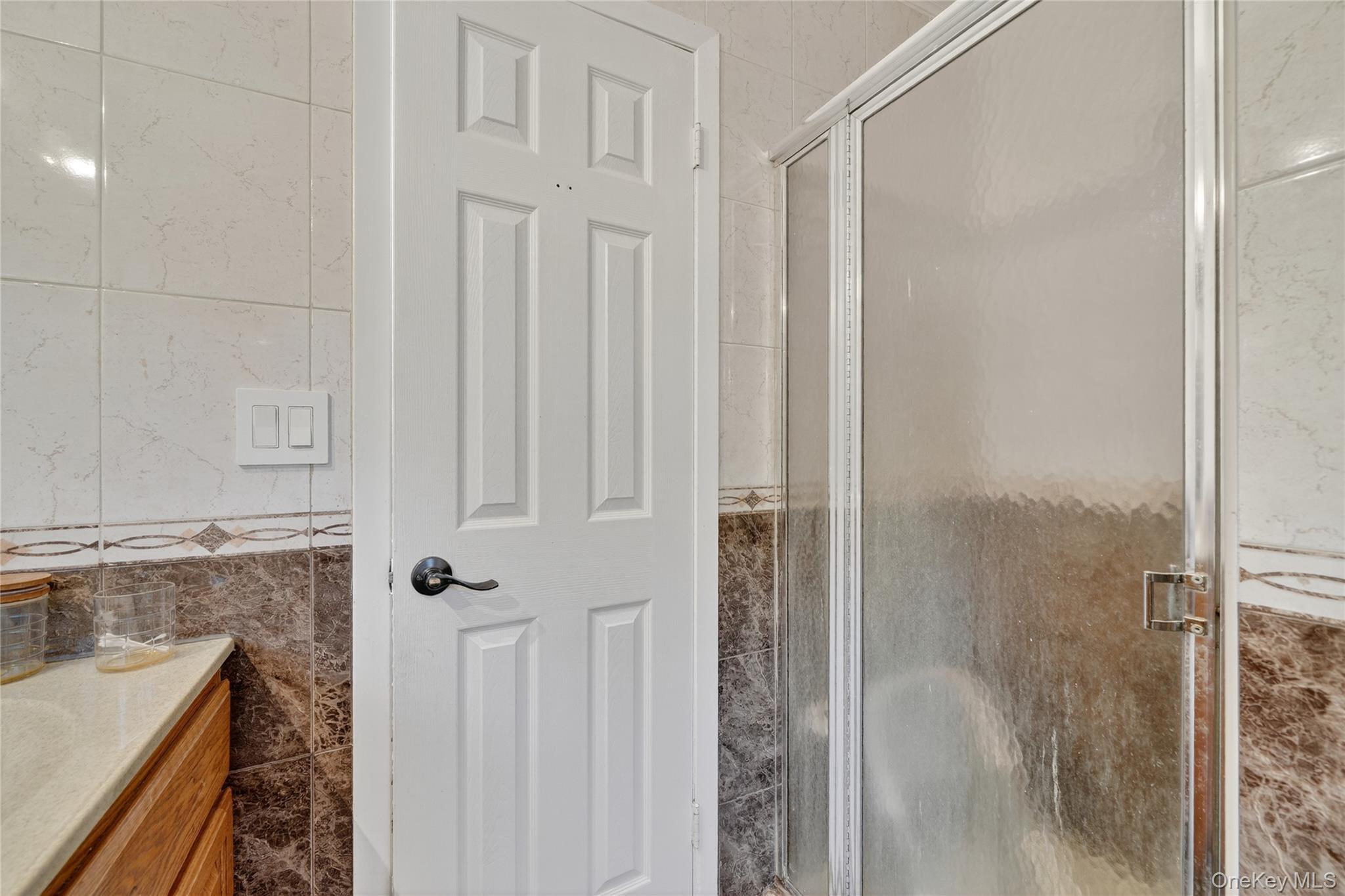 306 South Pascack Road Nanuet, NY 10954 - Photo 24 of 48 Full bathroom featuring tile walls, a stall shower, and vanity