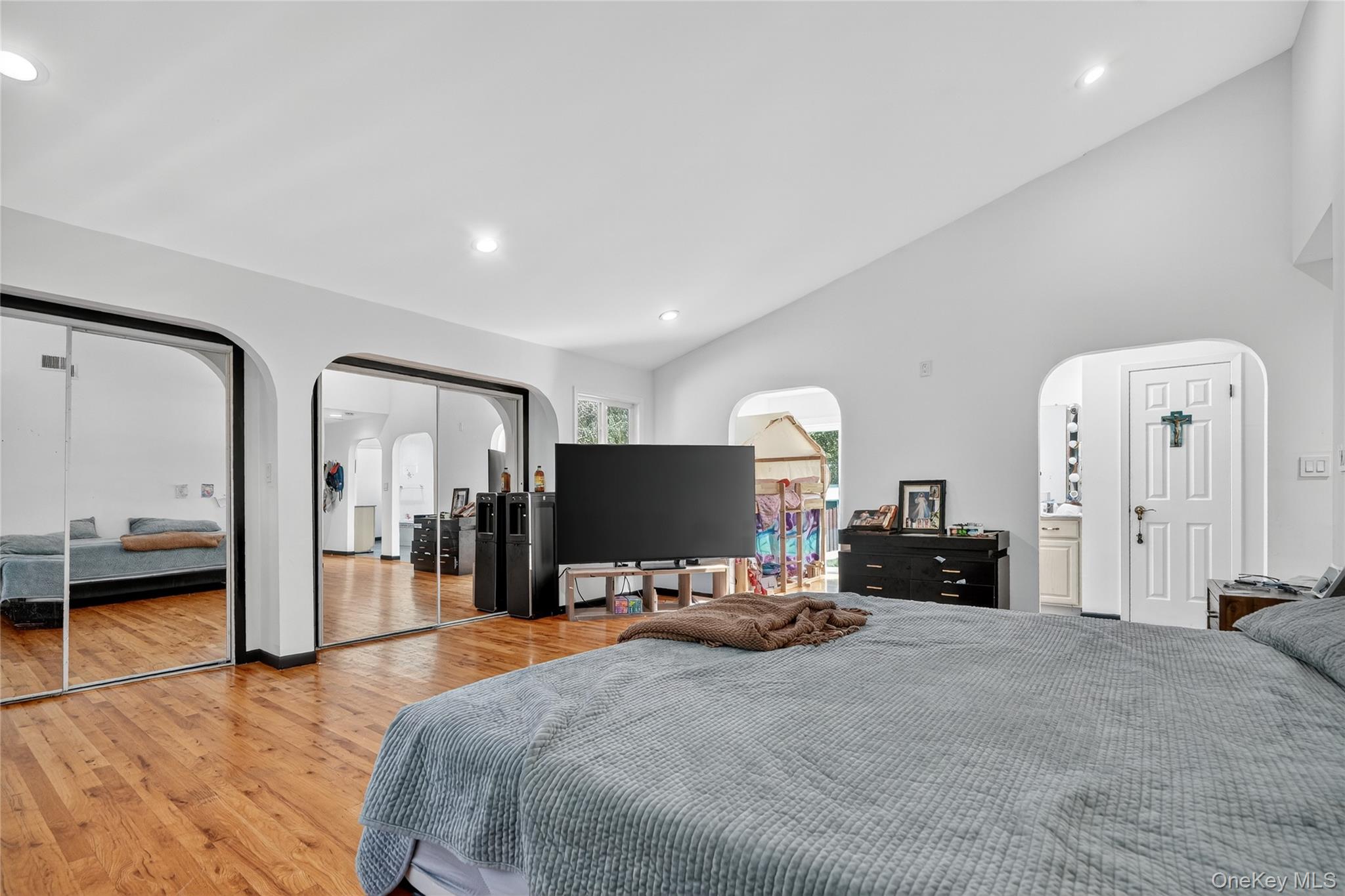 306 South Pascack Road Nanuet, NY 10954 - Photo 30 of 48 Bedroom with arched walkways, two closets, recessed lighting, light wood-style floors, and lofted ceiling