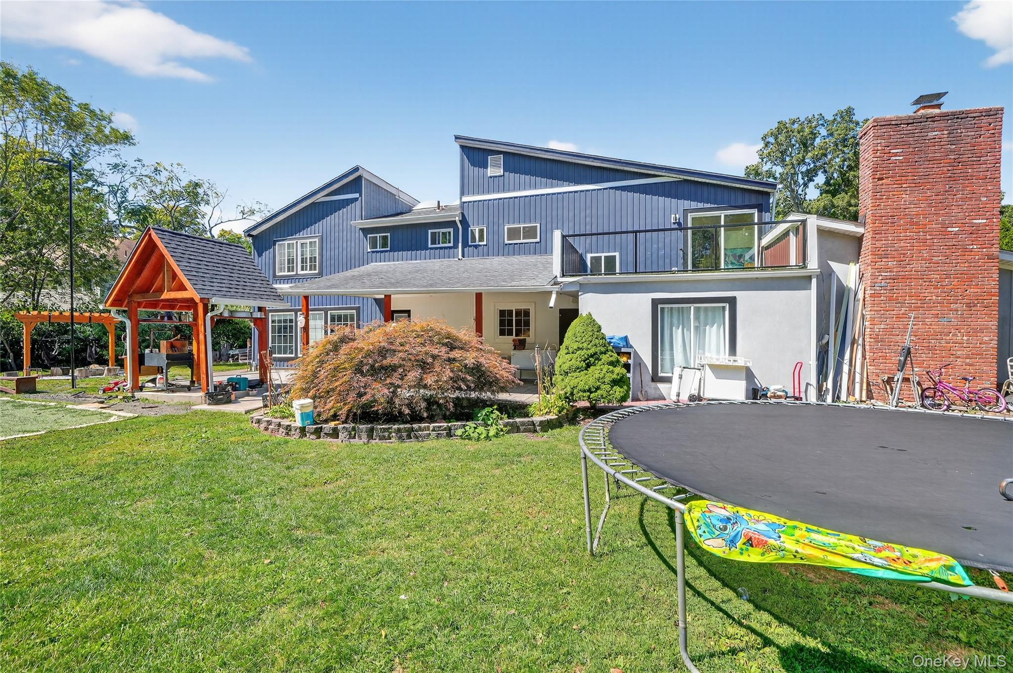 306 South Pascack Road Nanuet, NY 10954 - Photo 37 of 48 Back of house featuring a patio, a trampoline, and a yard
