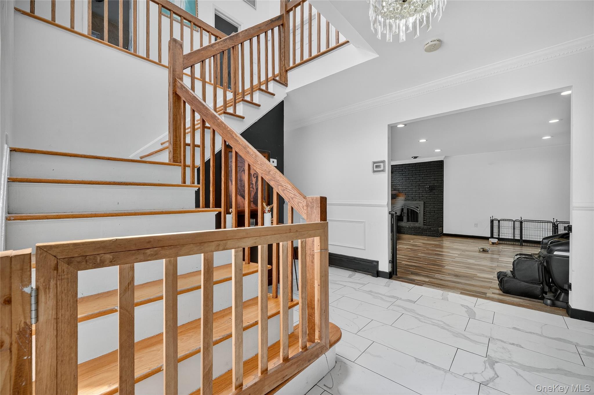 306 South Pascack Road Nanuet, NY 10954 - Photo 7 of 48 Staircase featuring ornamental molding, a brick fireplace, marble finish floors, and a towering ceiling