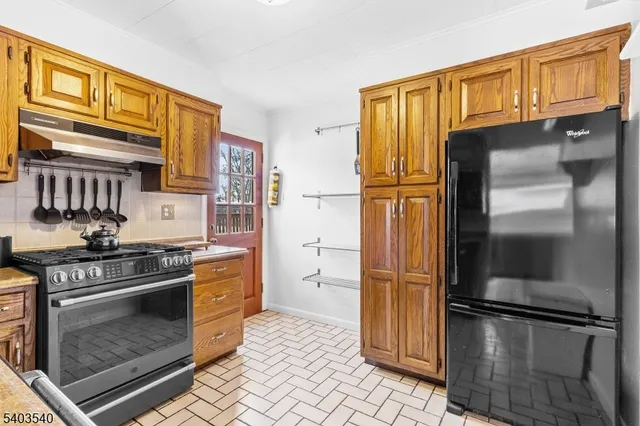 a kitchen with stainless steel appliances granite countertop a refrigerator stove and sink