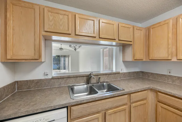 a kitchen with stainless steel appliances granite countertop white cabinets and a sink
