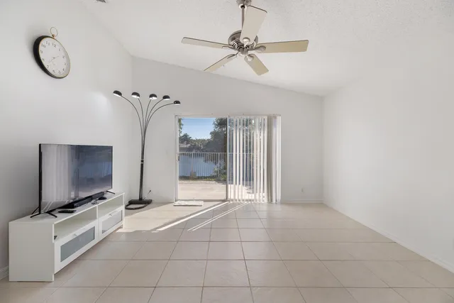 a living room with furniture a flat screen tv and a floor to ceiling window