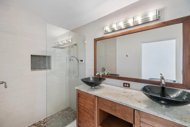 a bathroom with a granite countertop sink a toilet a mirror and bathtub