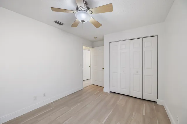 an empty room with a window and a fan