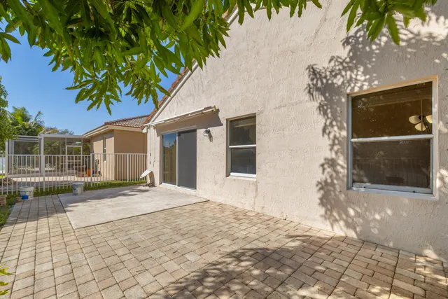 a backyard of a house with plants and trees with wooden fence