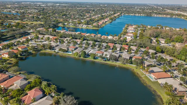 an aerial view of residential houses with outdoor space and trees