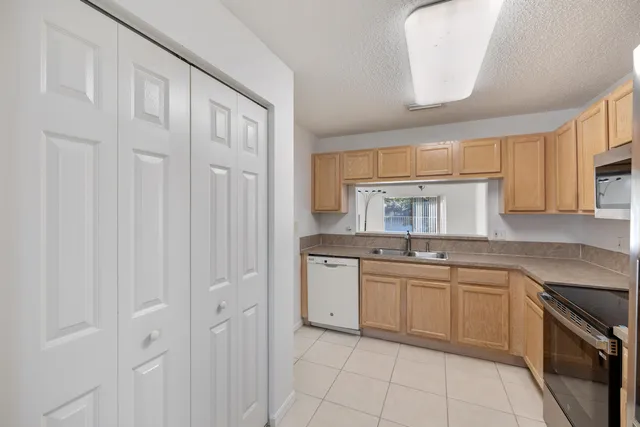 a kitchen with stainless steel appliances granite countertop a sink and dishwasher a stove with white cabinets