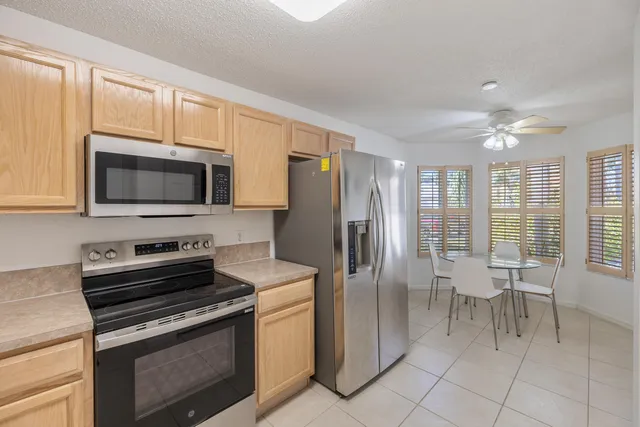 a kitchen with stainless steel appliances granite countertop a stove a refrigerator and a microwave