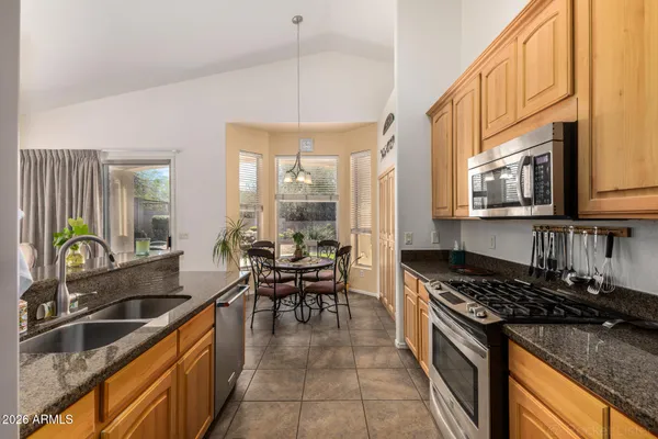 a kitchen with stainless steel appliances granite countertop a sink stove and cabinets