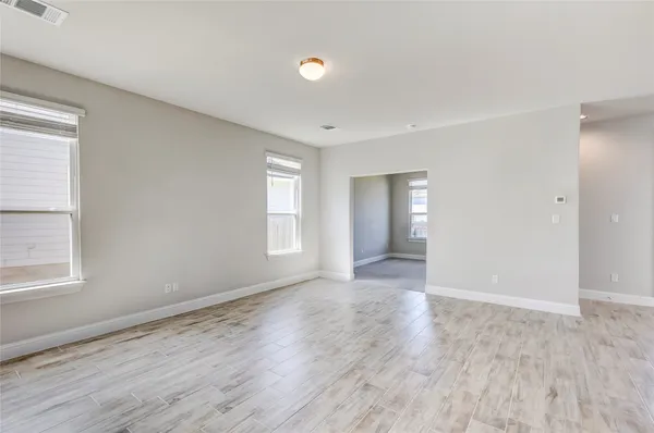 a large kitchen with kitchen island a sink dishwasher stove and white cabinets with wooden floor