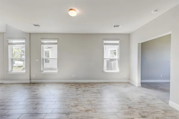 a kitchen with stainless steel appliances granite countertop a stove a sink a refrigerator and white cabinets with wooden floor