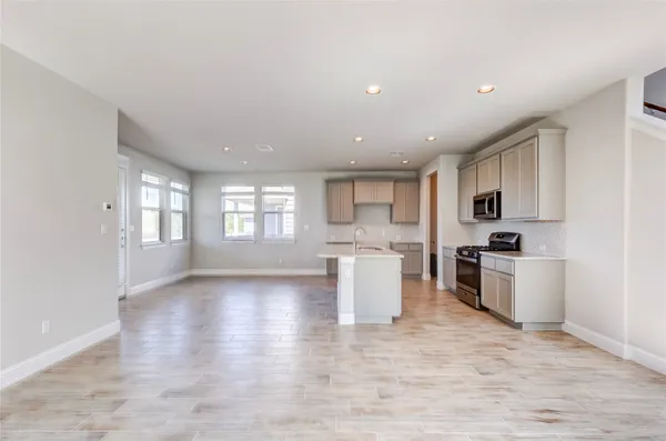 a kitchen with stainless steel appliances granite countertop a sink stove and wooden floor