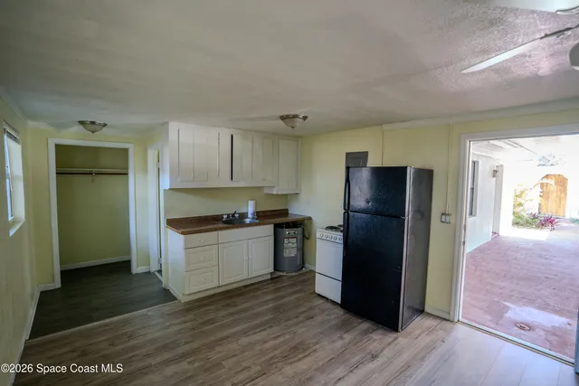 a kitchen with a refrigerator and a stove top oven