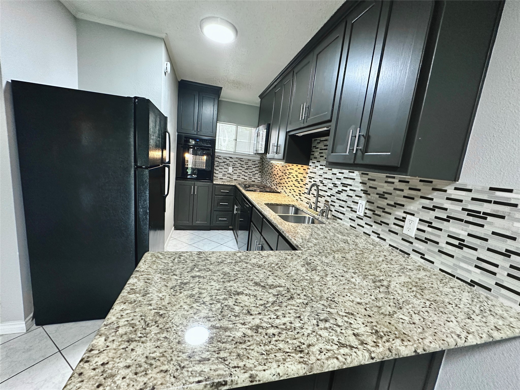 a view of a kitchen with stainless steel appliances kitchen island granite countertop wooden cabinets and a granite counter tops